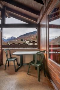 a table and two chairs in a room with a window at Grand studio tout confort pour 4 personnes in Brides-les-Bains