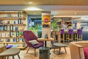 a restaurant with purple chairs and a bar at Campanile Lyon Centre - Berges du Rhône in Lyon