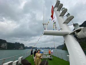 una mujer caminando en la cubierta de un barco en Quynh Yen Hotel, en Ha Long