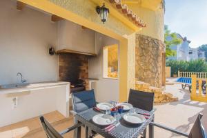 patio con mesa y sillas y cocina en Villa Castillo - PlusHolidays, en Benissa