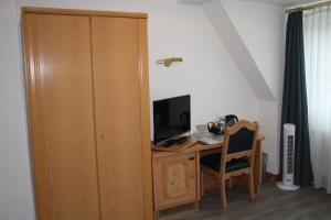 Zimmer mit einem Schreibtisch, einem Computer und einem TV. in der Unterkunft Pension / Ferienwohnung Allebrodt in Lennestadt