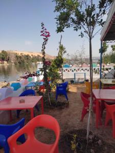 un gruppo di tavoli e sedie accanto a un fiume di Hamo Guest House a Aswan