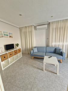 a living room with a blue couch and a table at Hostal Alba in La Mata