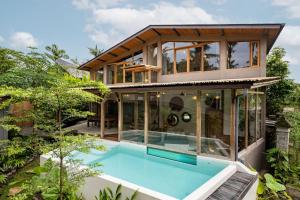 ein Haus mit Pool davor in der Unterkunft Casa Pohon Ubud in Ubud