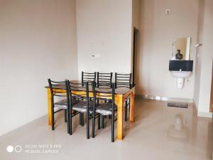 Cette chambre dispose d'une table avec des chaises et de toilettes. dans l'établissement Eve's Residency, à Meppādi