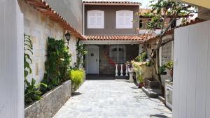 un callejón que conduce a una casa con una puerta blanca en Casa aconchegante perto das praias, en Arraial do Cabo