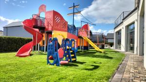 un parque infantil con un tobogán en el césped en Pensjonat Latino, en Rowy