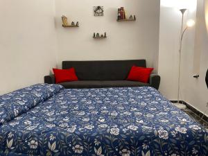 un letto con piumone blu e bianco e un divano di INANNA HOME a Bari