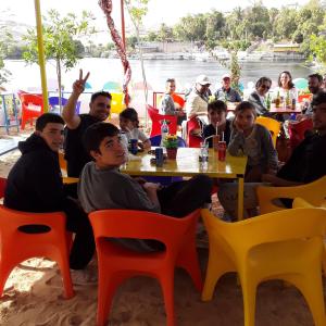 eine Gruppe von Menschen, die an einem Tisch in einem Restaurant sitzen in der Unterkunft Hamo Guest House in Assuan