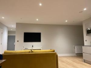 a living room with a couch and a flat screen tv at Thats The Pad - 2 Bedroom pied-a-terre apartment in Wimbledon in London