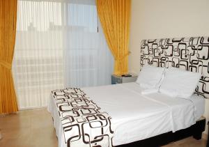 a bedroom with a bed with a black and white bedspread at KALINA HOTEL in Girardot