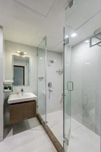 a bathroom with a glass shower and a sink at The Fern Residency Galaxy Mall in Āsansol