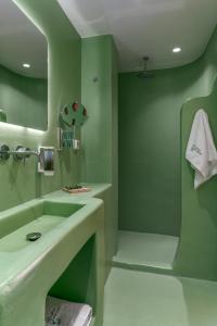 a green bathroom with a sink and a tub at LOFUS Bio-Suites in Athens