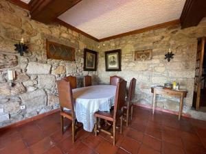 a stone walled dining room with a table and chairs at Casa do Alto (ground floor apartment) in Adaúfe