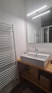 a bathroom with a white sink and a mirror at Les Suites du Monetier, alliant le charme et l'authenticité d'un chalet de prestige au cœur du village in Le Monêtier-les-Bains