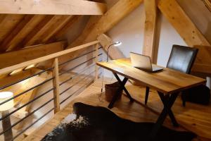 een laptop op een houten tafel op zolder bij Les Suites du Monetier, alliant le charme et l'authenticité d'un chalet de prestige au cœur du village in Le Monêtier-les-Bains