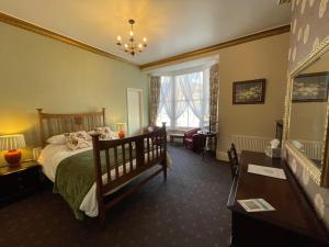 a bedroom with a bed and a chair and a table at The Captain's Lodge accommodation in Whitby