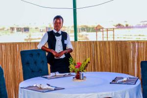 a man standing in front of a table at Amanya King Lion 1-Bed Wigwam in Amboseli in Amboseli