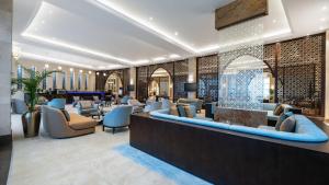 un hall d'un hôtel avec des chaises et un bar dans l'établissement Grand Millennium Gizan, à Jazan