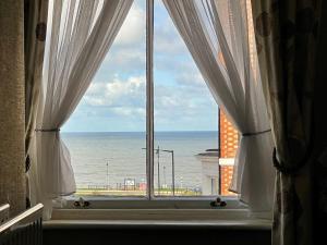 an open window with a view of the ocean at The Captain's Lodge accommodation in Whitby