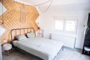 une chambre avec un lit avec une tête de lit en bois dans l'établissement Family home, near therme/airport/ lake, Balotesti, à Căciulaţi