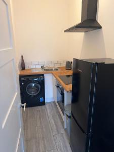 a kitchen with a black refrigerator and a dishwasher at Liley Apartments in Stockton-on-Tees +3 photos
