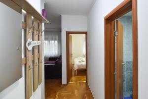 a hallway with an open door and a bedroom at Apartman ZORA in Subotica