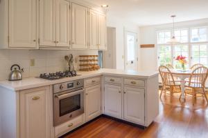 una cocina con armarios blancos y una mesa con comedor. en Parker House, en Camden