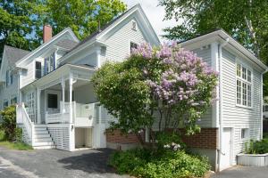 una casa blanca con un árbol floreciente delante de ella en Parker House, en Camden