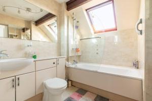 a bathroom with a tub and a sink and a toilet at Willow Ridge - a large country house with a king and Single or Twin room in Clutton