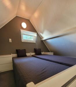 een slaapkamer met 2 bedden op een zolder bij Vakantiehuis 6 pers, Oostduinkerke aan zee in Koksijde