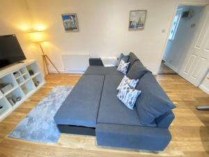 a living room with a blue couch and a television at Dragon Cottage By Gunwharf Quays & Historic Dockyard in Portsmouth