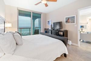 Portofino Island Resort & Spa Tower Two 1306 في شاطئ بينساكولا: غرفة نوم مع سرير وإطلالة على المحيط