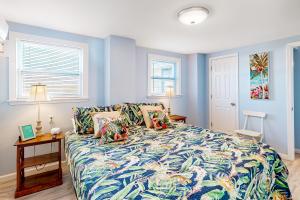 1 dormitorio con 1 cama con colcha colorida en First Street Retreat Lower, en Mexico Beach