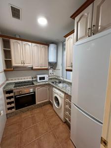 una cucina con frigorifero bianco e lavastoviglie di ATICO SUITE CLAUDIO MARCELO a Cordoba