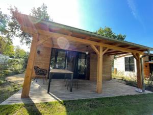 a pavilion with a table and chairs on a deck at Tiny House am Veluwemeer im Europarcs Bad Hoophuizen in Hulshorst