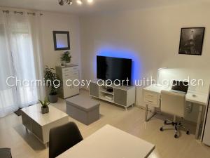 a living room with a flat screen tv and a couch at Charming cosy apart with garden free parking in Claye-Souilly