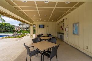 a patio with tables and chairs and a pool at Bali Villa at Ko Olina 30 plus Night Rental in Kapolei