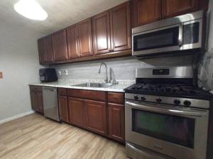 a kitchen with stainless steel appliances and wooden cabinets at Beach House in Pensacola