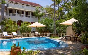 迪亞尼海灘的住宿－藍馬林海灘酒店，酒店前方的游泳池配有椅子和遮阳伞