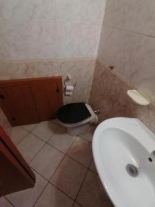 een badkamer met een zwart toilet en een wastafel bij Darius Palace in Sartano