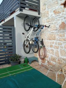 una bicicletta appesa a un muro accanto a una sedia di Apartment Patrik a Vabriga