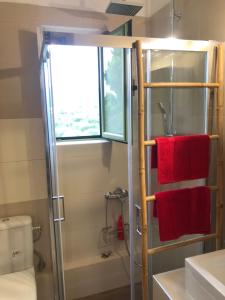 a bathroom with a shower and red towels at Kakovatos - Luxury sea view apartment “Theodora” 54m2. in Kakóvatos