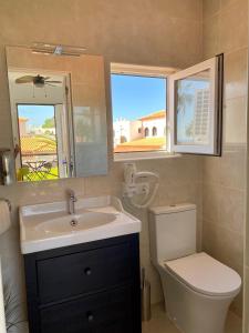 Juangy’s Apartments in Las Adelfas Golf del Sur في سان ميغيل ذي أبونا: حمام مع حوض ومرحاض ومرآة