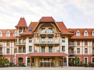 duży budynek z czerwonymi dachami w obiekcie TRIBE Hôtel Le Touquet w mieście Le Touquet-Paris-Plage