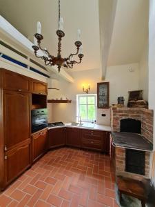 a large kitchen with a brick floor and a chandelier at Morowo chałupa in Czchów