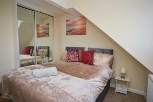 a bedroom with a large bed with red pillows at London's Calling U! A Lovely 2 BedHome Sleeps 1-5! in London