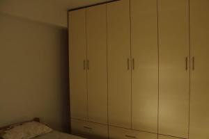 a bedroom with white cabinets and a bed at Cozy convenient stay in Skopje in Skopje