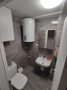 a bathroom with a white toilet and a sink at Cozy convenient stay in Skopje in Skopje