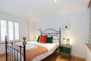 a bedroom with a bed with orange and green pillows at Apartment in the heart of the city centre, live like a local in Oxford